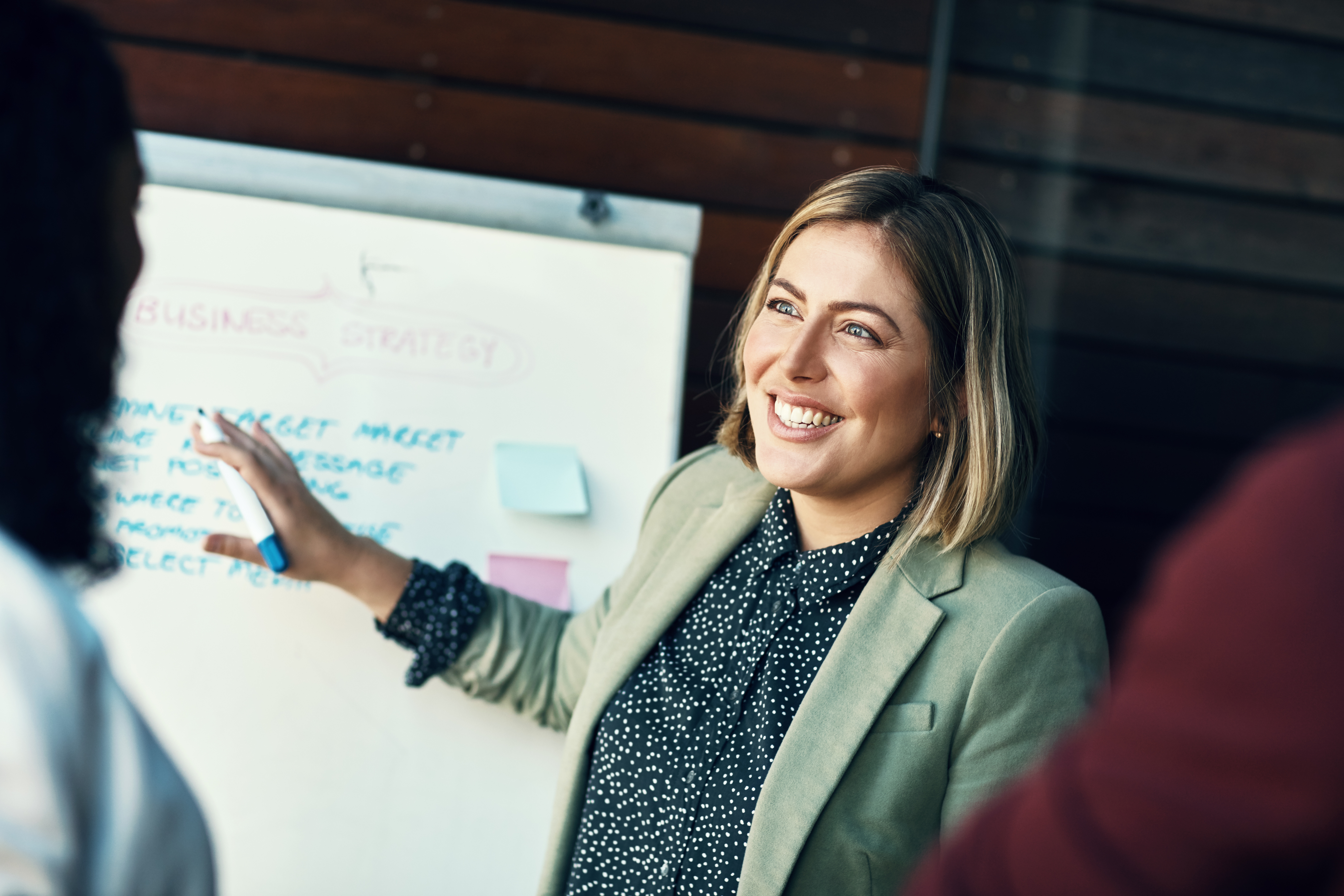 Woman is dicussing something with colleages pointing to a presentation board
